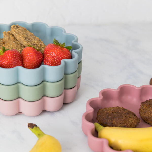 three flower plates stacked with strawberries on top and a raspberry sorbet flower plate to the side with a banana and weetabix muffin on